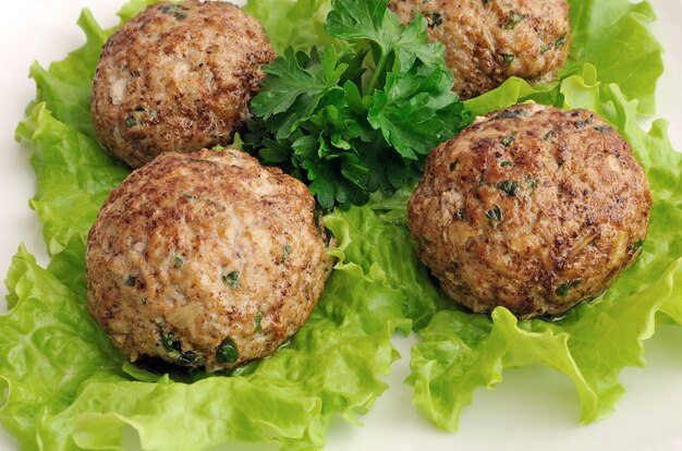 Eine Frikadelle mit Grüns auf Salatblättern Nahaufnahme