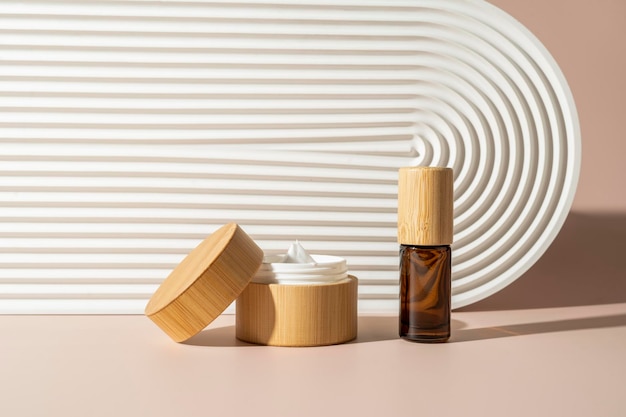 Eine frische Gesichtscreme in einer Holzkiste und ätherisches Öl in der Nähe des weißen Keramiktabletts Produktmarketing-Kosmetikmodell