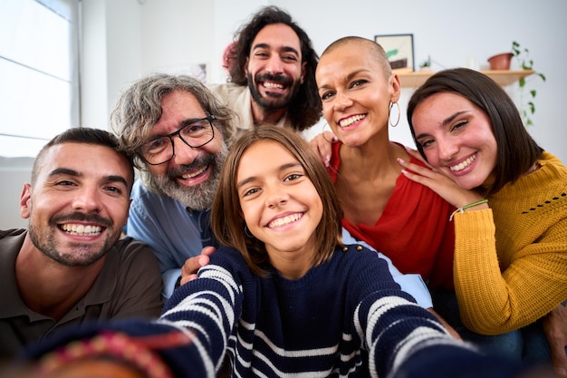 Foto eine fröhliche kaukasische familie lächelt, umarmt sich und macht ein selfie im innenraum. glückliche menschen im häuslichen leben.