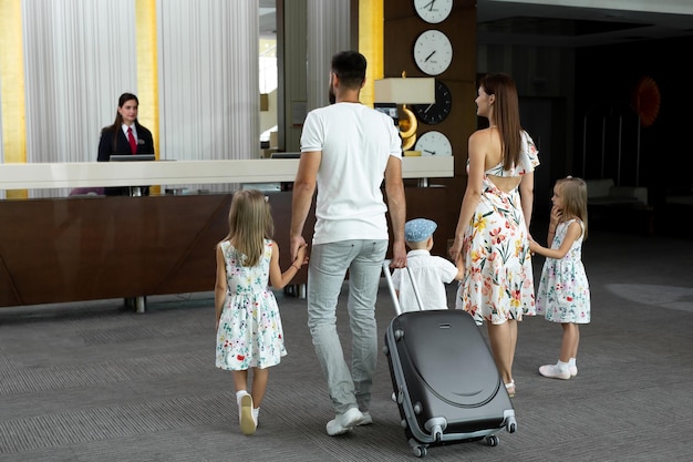 Eine fünfköpfige Familie betritt die Hotellobby, um an der Rezeption für den Urlaub einzuchecken