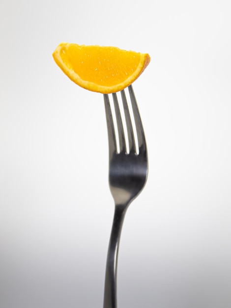 Eine Gabel mit einem Stück Orange darauf