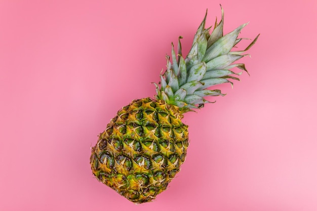 Eine ganze Ananas auf rosa Hintergrund Ansicht von oben