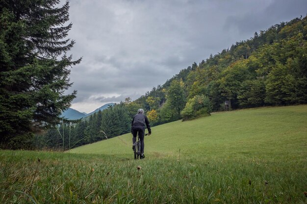 Foto eine ganze länge eines mannes, der auf dem feld gegen den himmel geht