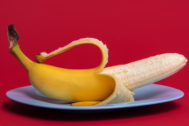 Foto eine gelbe banane auf rotem grund.