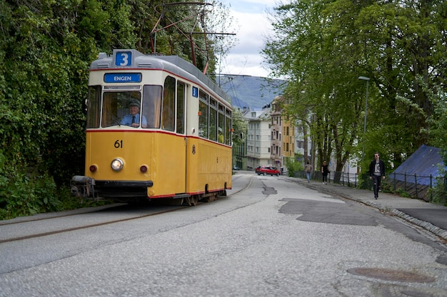 Eine gelbe Straßenbahn mit der Nummer 61 auf der Vorderseite fährt die Straße hinunter.