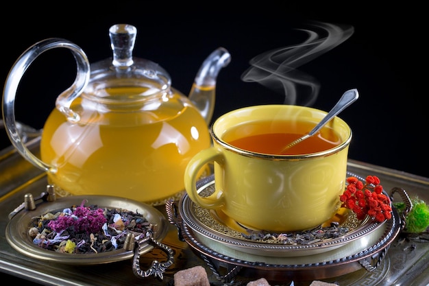 Eine gelbe Tasse Tee steht neben einer gelben Tasse Tee.