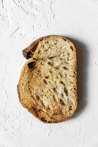 Foto eine geröstete scheibe vollkornbrot auf draufsichtschuß des weißen hintergrundes