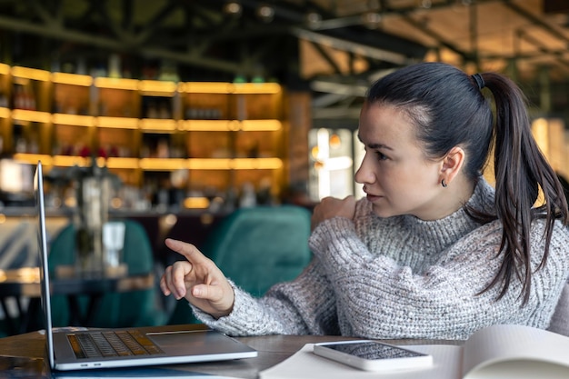 Eine Geschäftsfrau arbeitet mit einem Laptop in einem Café
