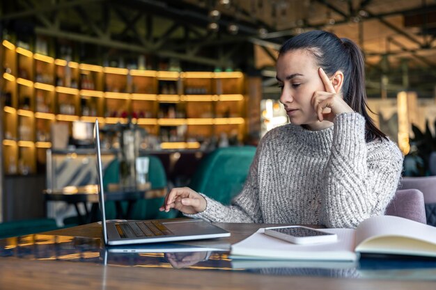 Eine Geschäftsfrau arbeitet mit einem Laptop in einem Café