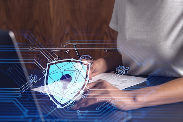 Eine Geschäftsfrau in Freizeitkleidung unterzeichnet den Vertrag, um die Wahrscheinlichkeit von Risiken in der Cybersicherheit zu verhindern. Vorhängeschloss-Hologramm-Symbole über dem Schreibtisch