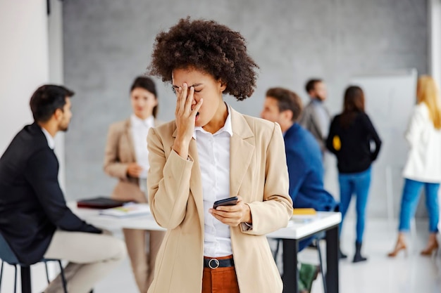 Eine Geschäftsfrau mit Misserfolg im Büro Sie las die schlechten Nachrichten am Telefon