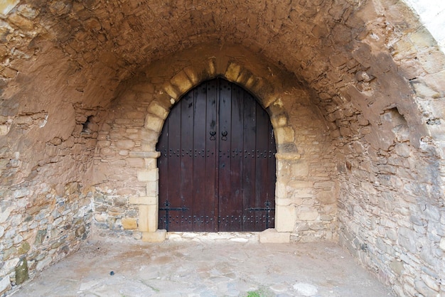 Eine geschlossene Holztür zu einem Gebäude aus Stein