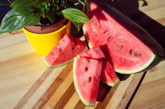 Eine geschnittene reife Wassermelone liegt auf einem Holztisch