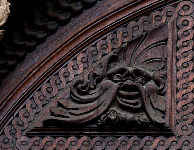 Eine geschnitzte Holztür mit einem Gesicht darauf.