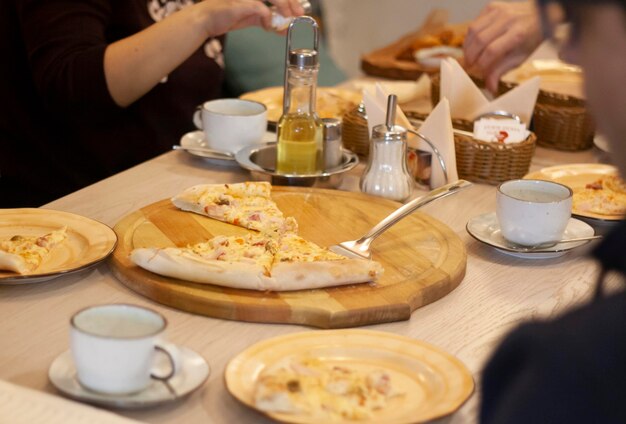 Eine Gesellschaft von Leuten, die in einem Restaurant Pizza essen