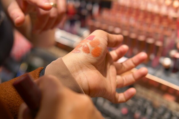 Foto eine geste, karminlippenstift auf das fleisch der hand einer anderen person aufzutragen