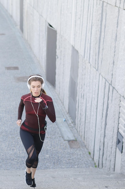 Foto eine gesunde, glückliche frau joggt, läuft im freien und hört musik