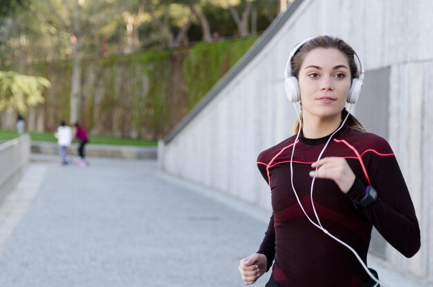 Foto eine gesunde, glückliche frau joggt, läuft im freien und hört musik