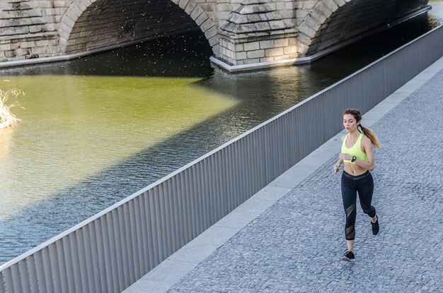 Foto eine gesunde, glückliche frau joggt, läuft im freien und hört musik