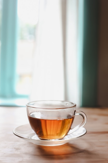 Eine Glastasse Tee auf einem Holztisch