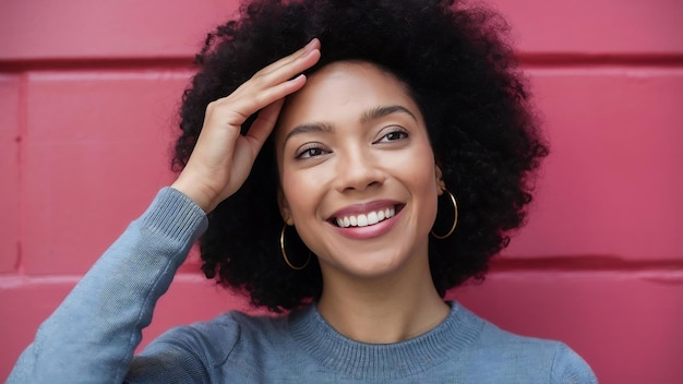 Eine glückliche afroamerikanische Frau berührt die Stirn, neigt den Kopf und lächelt glücklich in die Kamera.