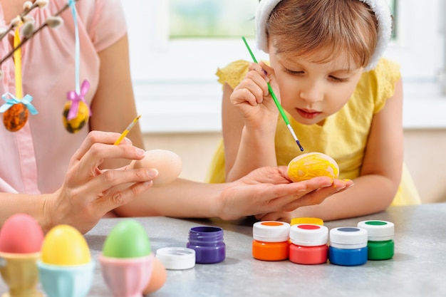 Eine glückliche Familie bereitet sich auf Ostern vor und bemalt Ostereier