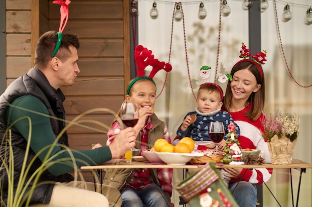 Eine glückliche Familie, die am Tisch sitzt und Weihnachten feiert