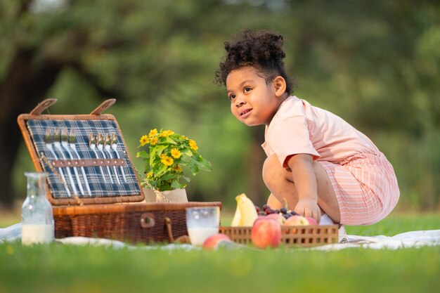 Eine glückliche Familie, die ein Picknick im Park genießt, mit Kindern, die Spaß haben und in der Natur sitzen