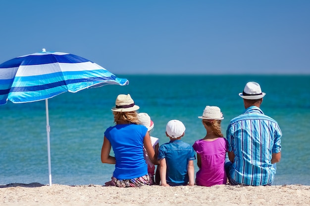 Eine glückliche Familie Eltern mit Kindern am Meer auf Naturreisen