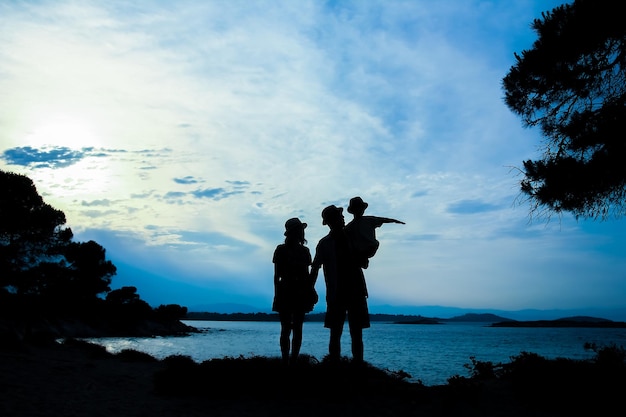 Eine glückliche Familie in der Natur am Meer auf einer Reisesilhouette