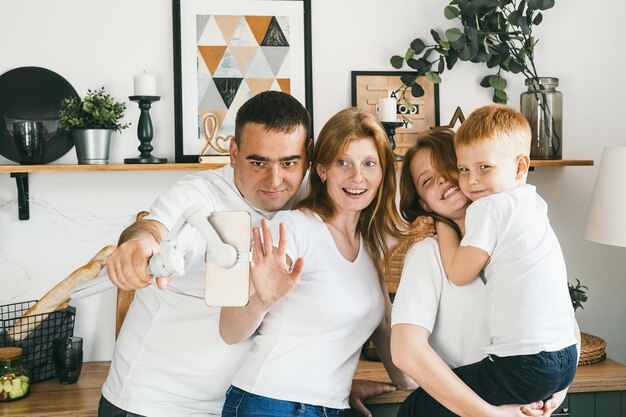 Foto eine glückliche familie macht ein selfie mit dem telefon in der küche zu hause