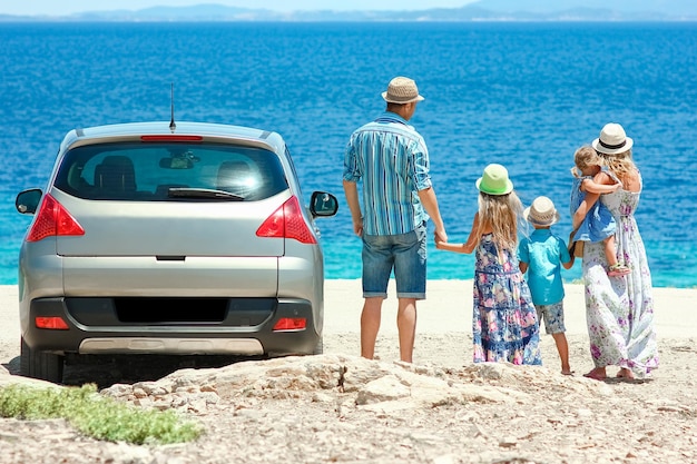 Eine glückliche Familie mit dem Auto am Meer in der Natur, Wochenendreise