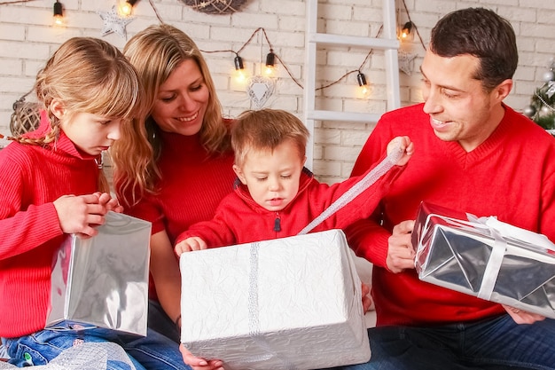 Eine glückliche Familie mit Geschenken an Weihnachten