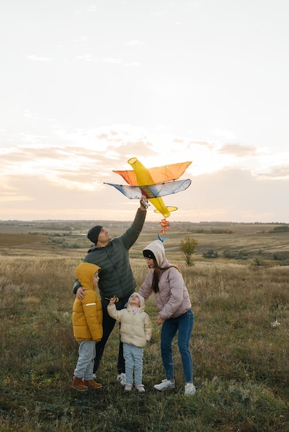 Eine glückliche Familie mit Kindern lässt einen Drachen steigen und verbringt gemeinsam Zeit im Freien in einem Naturschutzgebiet Glückliche Kindheit und Familienurlaub Freiheit und Weite