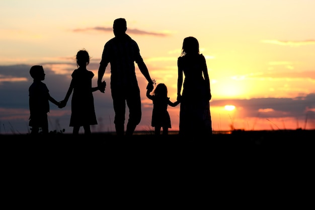 Eine glückliche Familiensilhouette auf See mit Reflexion im Park in der Natur