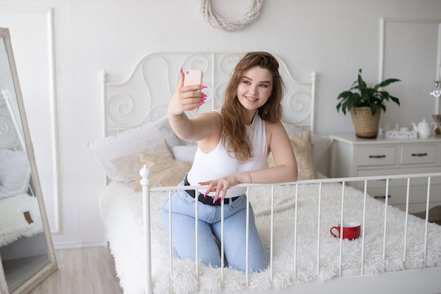 Eine glückliche Frau hat ein Selfie Das Mädchen schaut in die Telefonkamera und lächelt