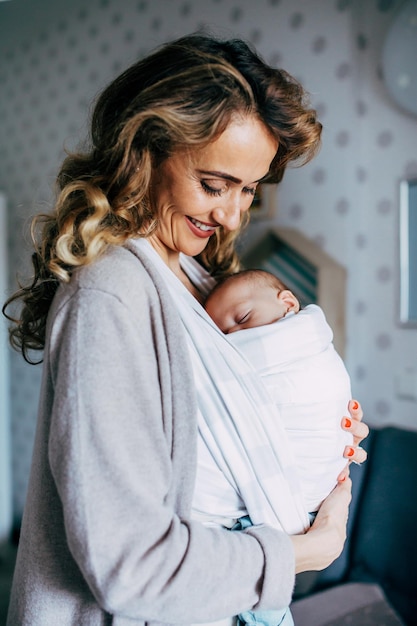 Eine glückliche Frau mit einem Baby, das zu Hause sitzt