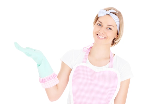 eine glückliche Haushälterin im Retro-Stil, die etwas auf weißem Hintergrund zeigt
