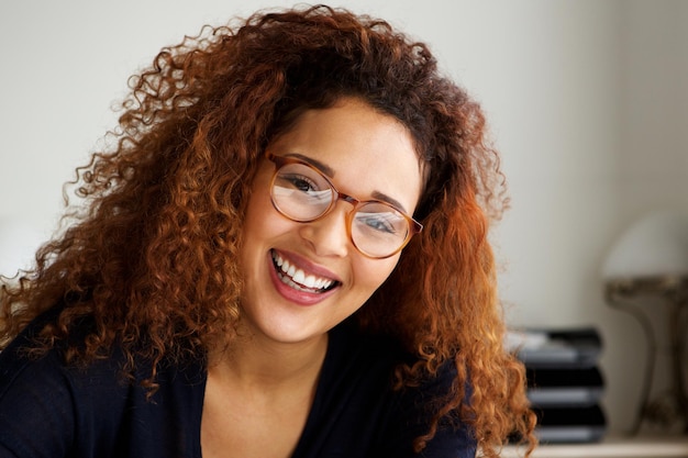 Eine glückliche junge Frau mit lockigem Haar und Brille