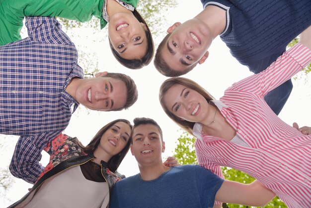 Eine glückliche, lächelnde Gruppe junger Freunde, die draußen im Park zusammen sind