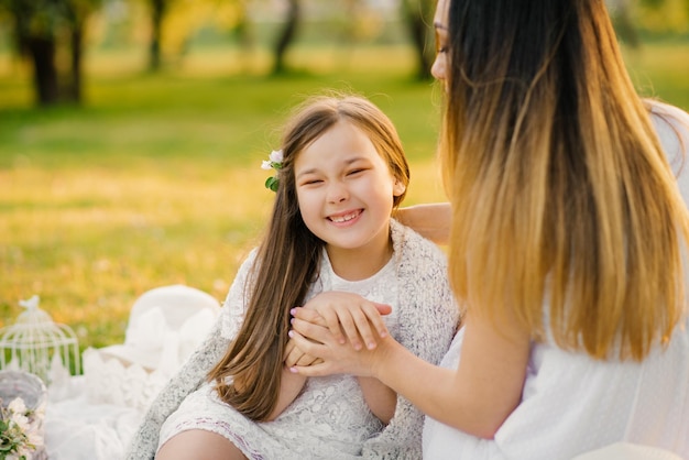 Eine glückliche Mutter und ihr Baby vergnügen sich im Sommer draußen im Park