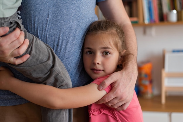 Eine glückliche, schöne Familie zusammen im Hausvater, der eine Kindertochter und einen Sohn umarmt