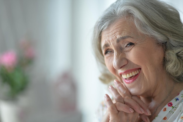 Eine glückliche Seniorin posiert zu Hause