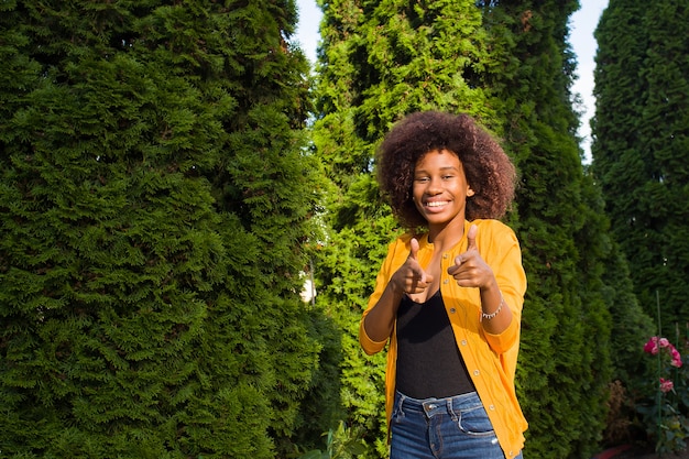 Eine glückliche und junge Afroamerikanerin geht die Straße entlang