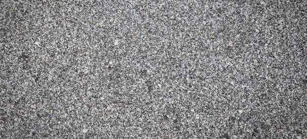Eine grau-weiße strukturierte Oberfläche mit einem schwarz-weißen Stein