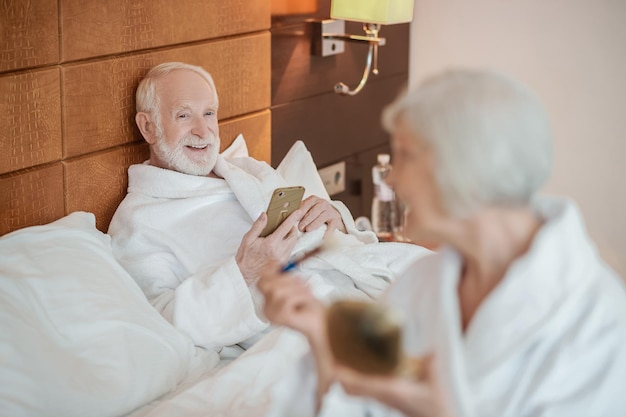 Eine grauhaarige Frau, die sich morgens schminkt