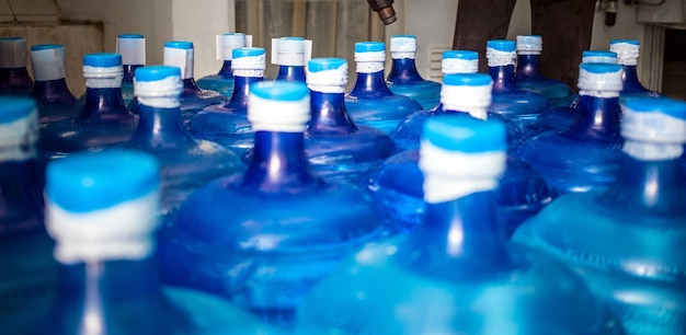 Eine große Anzahl blauer Kunststoff-Gallonen von Trinkwasserprodukten in einer Trinkwasseranlage