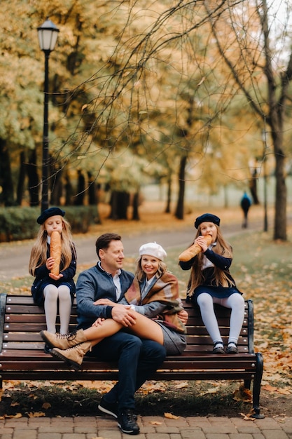 Eine große Familie sitzt auf einer Bank in einem Herbstpark Glückliche Menschen im Herbstpark