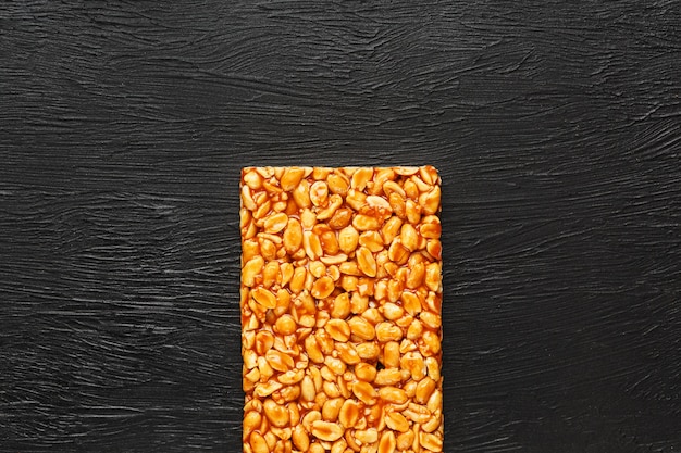 Eine große goldene Fliese mit Erdnüssen, eine Tafel mit süßer Melasse. Kozinaki nützliche und leckere Süßigkeiten aus dem Osten