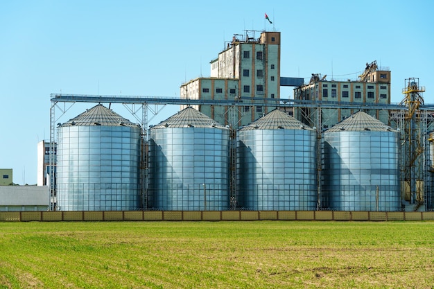 Eine große moderne Anlage zur Lagerung und Verarbeitung von Getreide Blick auf den Getreidespeicher an einem sonnigen Tag gegen den blauen Himmel Ende der Erntesaison